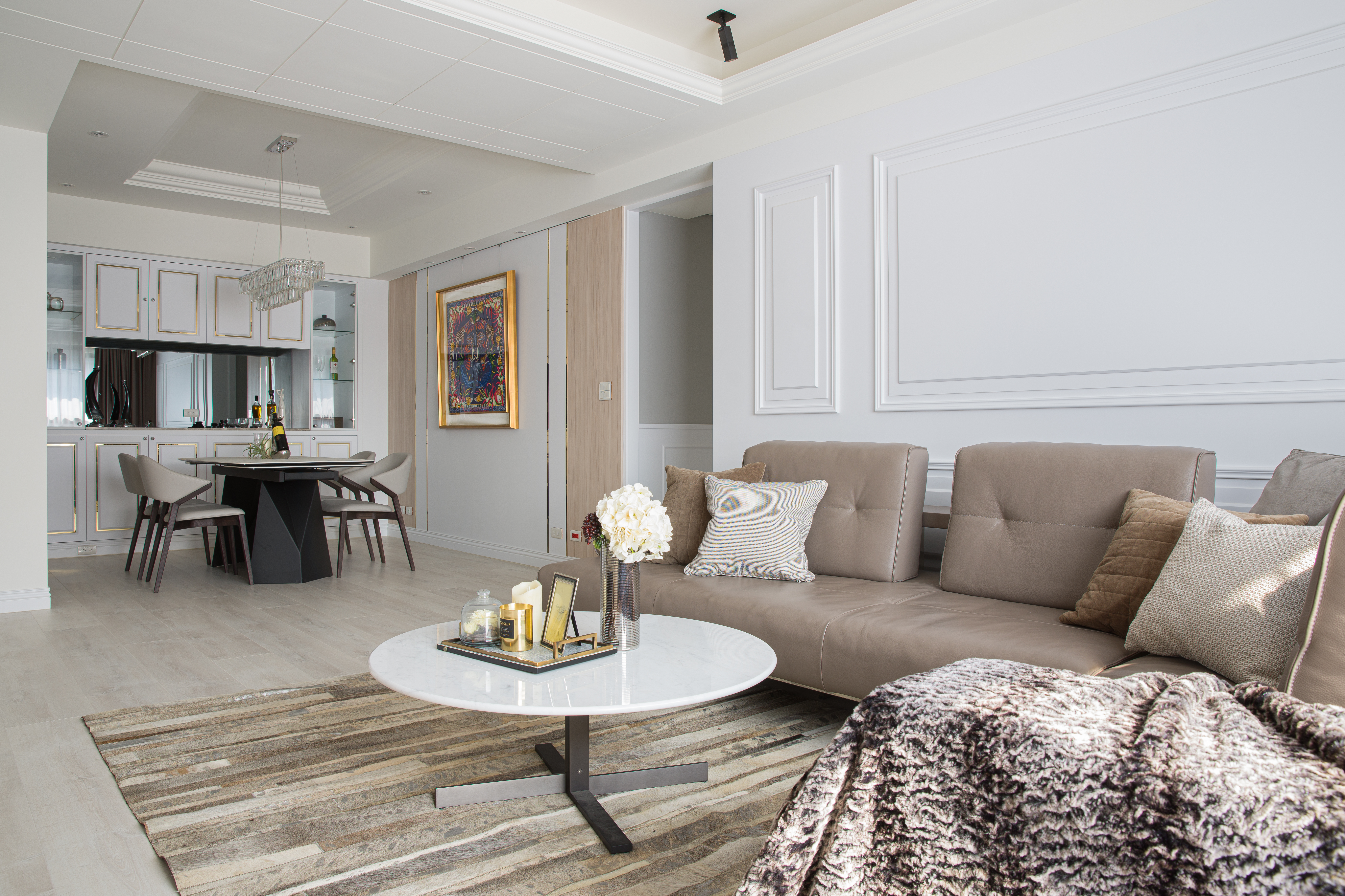 融合歐式輕奢風與現代簡約設計，客廳以大理石圓桌、絨布沙發、線板裝飾打造高級氛圍。開放式餐廳與鏡面收納櫃提升空間感，水晶吊燈點綴出奢華氣息，營造高質感生活空間。