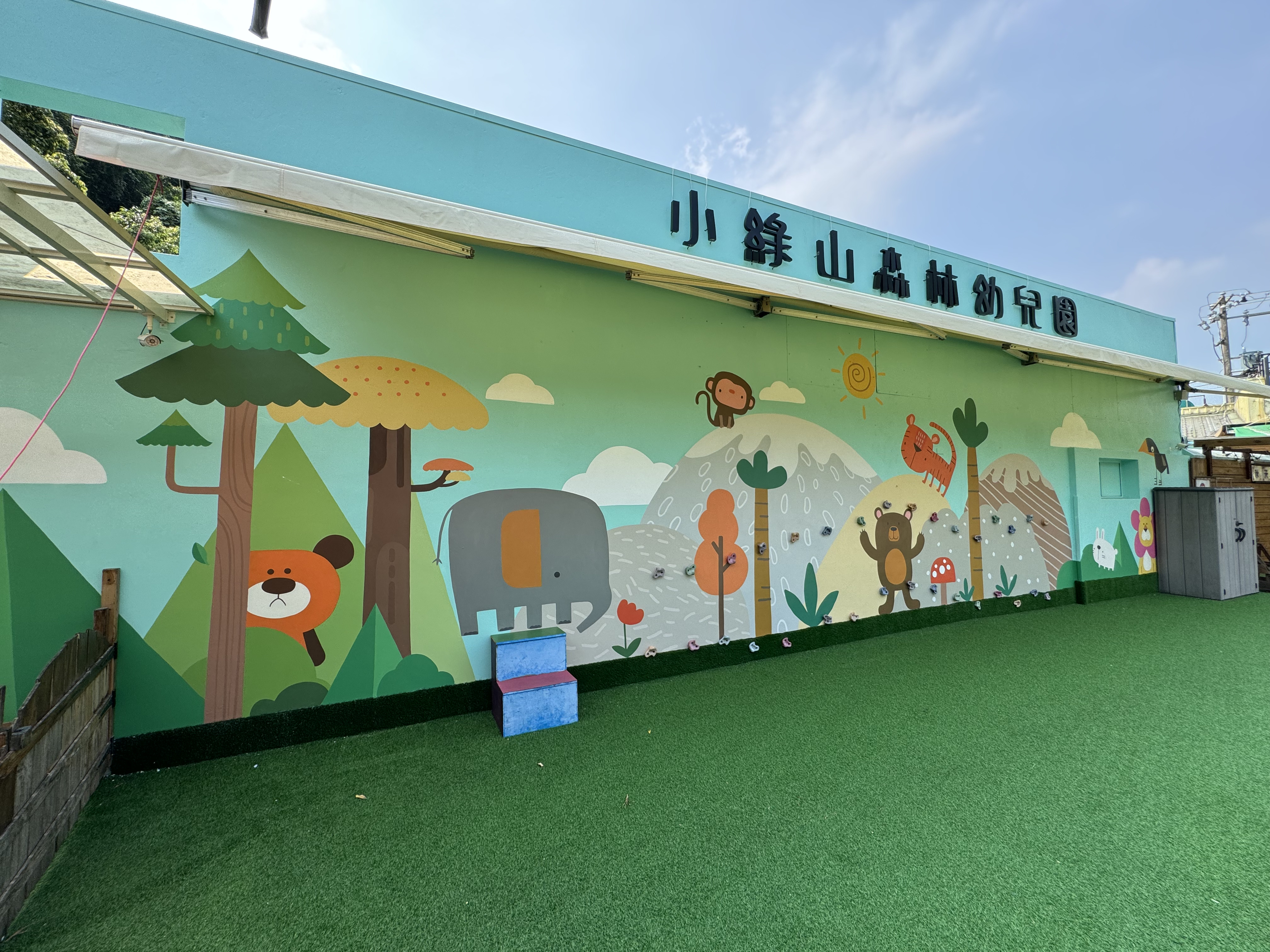 小綠山森林幼兒園進行外牆美化工程，以自然童趣設計融入綠意環境，打造溫馨友善的學習空間。透過牆面彩繪、植生設計與安全改造，提升園區視覺美感與孩童探索樂趣，提供更優質的學習與遊戲環境。